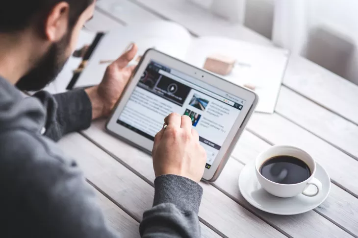 man browsing an article on a tablet