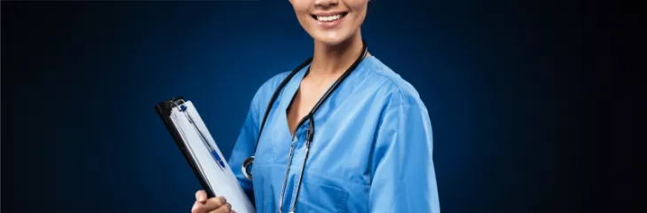Nurse in a blue scrub wearing a stethoscope and holding a clipboard