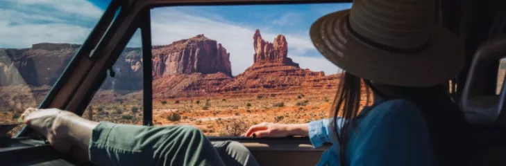 Girl in a car looking outside from the window  wearing blue shirt and green pent