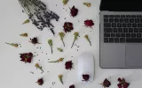 laptop on desk with scattered flowers