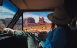 Girl in a car looking outside from the window  wearing blue shirt and green pent